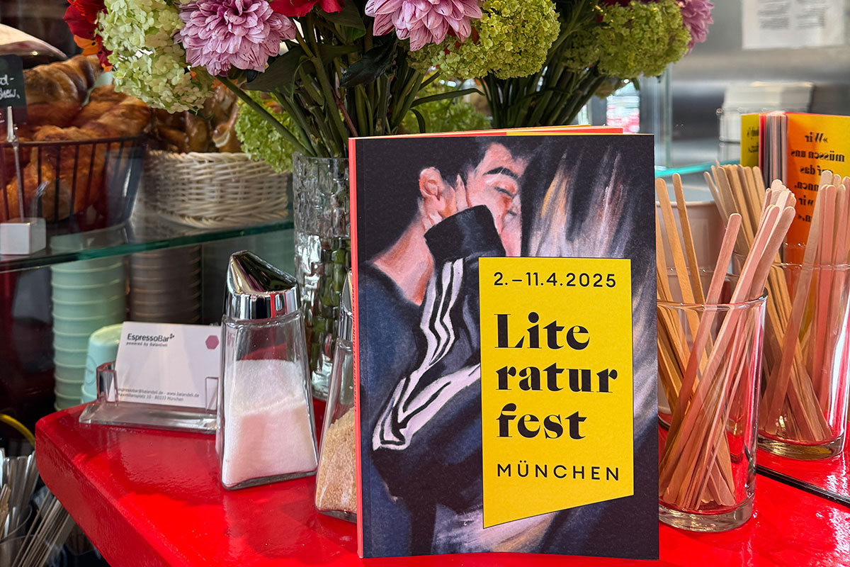 Das Programmheft des Literaturfestes München vor Blumenstrauß